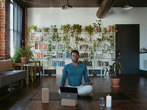 Man sitting in meditation in front of a laptop computer